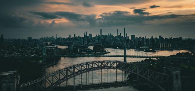 a bridge over a river with a city in the background by Venti Views courtesy of Unsplash.