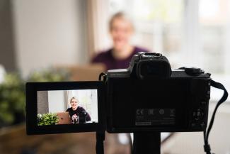 black nikon dslr camera on black stand by Jodie Cook courtesy of Unsplash.